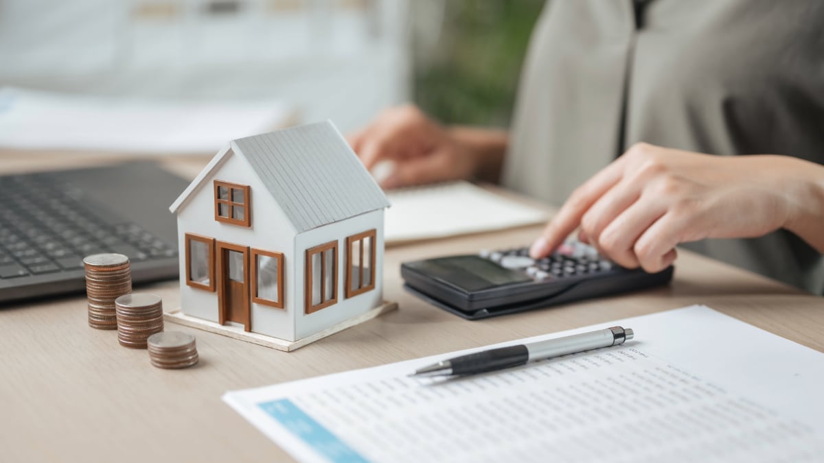 Une personne fait des calculs pour l'achat d'une maison.