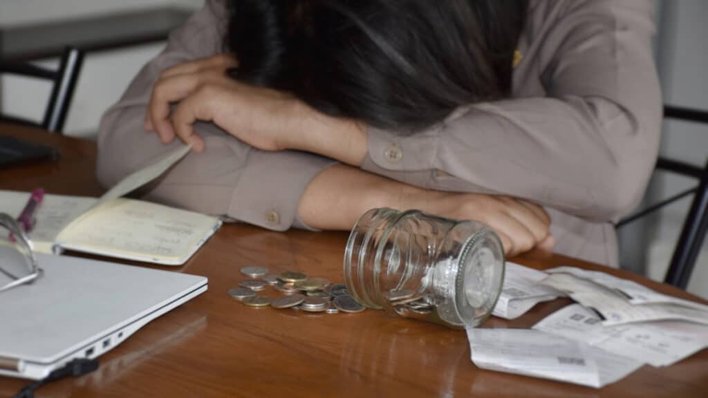 Une femme devant quelques pièces de monnaie et des tickets.