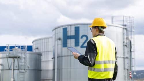 Un ingénieur sur fond d'usine d'hydrogène.